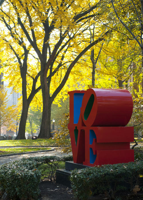 The love sculpture on campus with fall foliage in the background.