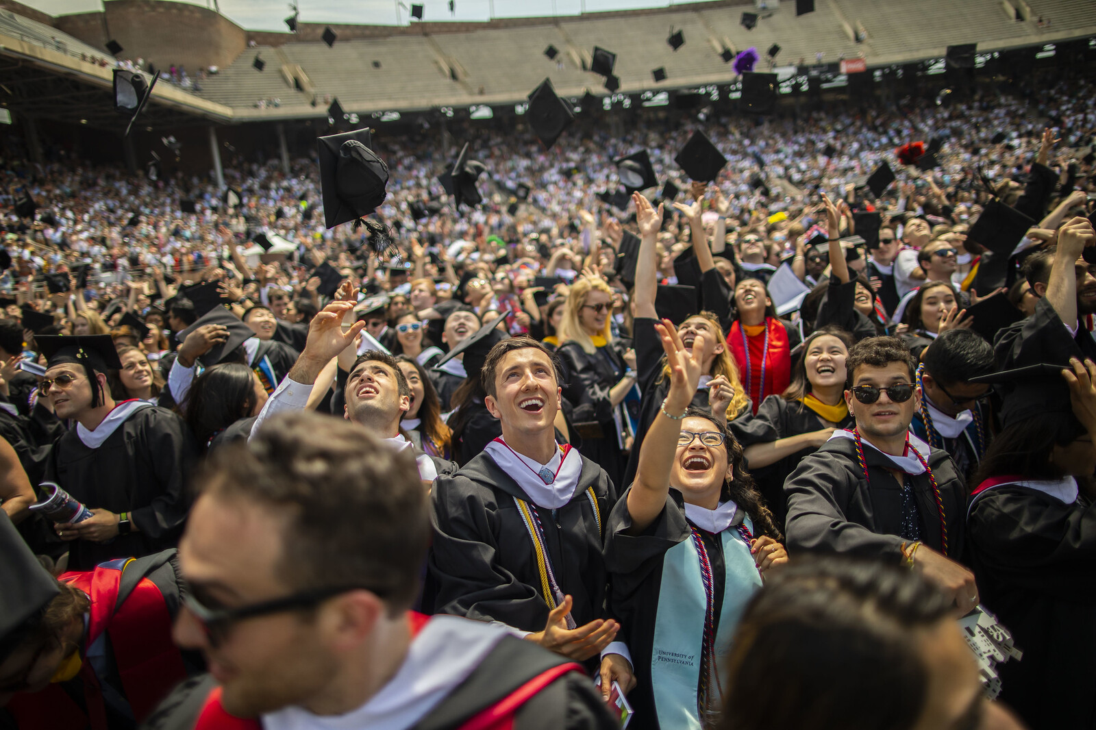 A sea of Penn graduates toss their mortar boards into the air at end of the 2019 commencement ceremony.